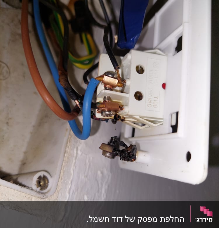 חוטי חשמל מחוברים לשקע עם סימני שריפה